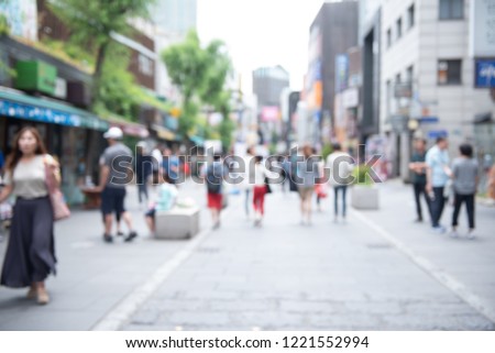 Blurred background, crowd people walking, shopping at outdoor shady walking street market in the city. Summer Holiday shopping in Korea