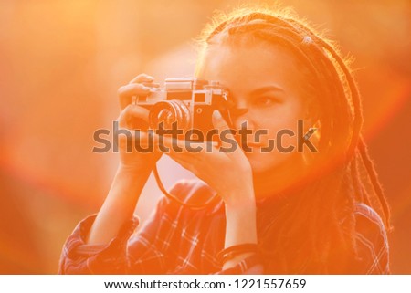 Hipster amazing photograph girl with dreads making pictures of the nature in the sunset in the forest, outdoor view