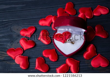 The box with engagement ring and red love hearts, close up. Valentine's Day concept.