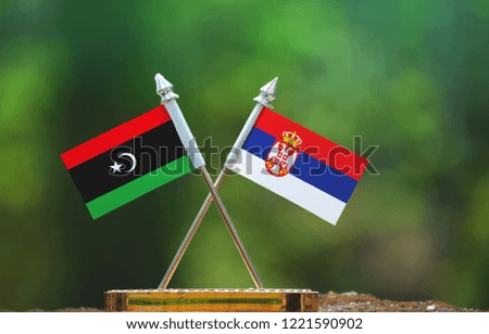 Serbia and Libya small flag with blur green background