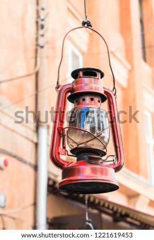Still life of old hurricane lamp on the street. Reportage photo. Vintage lamp. Kerosene lamp. Old-fashioned equipment. Ancient decorations. Retro gas lamp.