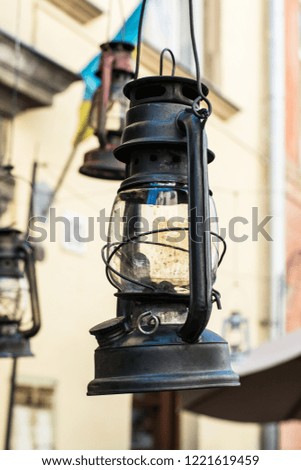 Still life of old hurricane lamp on the street. Reportage photo. Vintage lamp. Kerosene lamp. Old-fashioned equipment. Ancient decorations. Retro gas lamp.