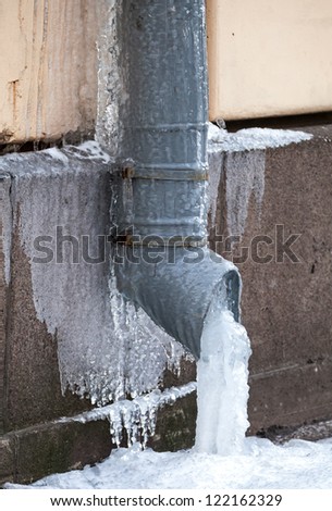 Winter city fragment. Icicles and frost on drainpipe Royalty-Free Stock Photo #122162329