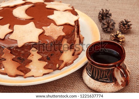 Chocolate cake on the plate and cup of coffee on the sackcloth