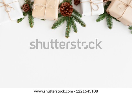 Christmas gifts with pine cones and leaves on a white table. Flat lay with blank copy space. Royalty-Free Stock Photo #1221643108
