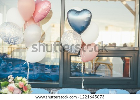 Bunch of pastel balloons and reflection of joyful crowd of wedding guests on the background