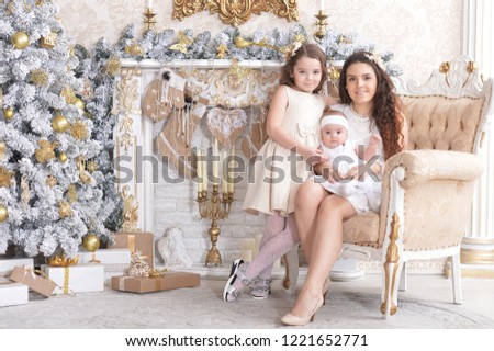Portrait of happy mother with cute little daughters posing