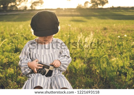 Portrait of a little girl taking pictures with a camera. Concept of adorable children playing