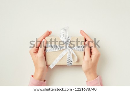 Woman hands holding gift box on white background, top view 