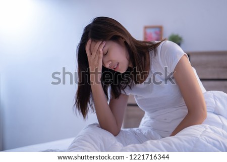 Asian woman have a headaches may be migraines in the morning on the bed 
