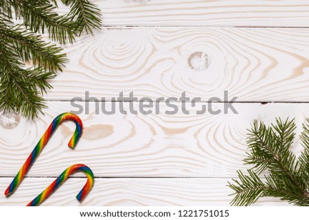 Christmas or New year background. Traditional Christmas colorful lollipops and fir branches, white wooden Board background, copy space, top view