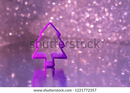 New year 2019 sparkle, shiny background with defocused violet plastic new year tree on blurred glow violet bokeh lights