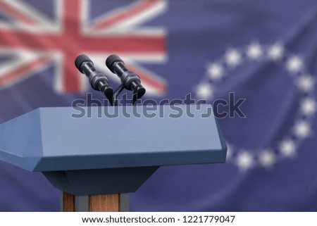 Podium lectern with two microphones and Cook Islands flag in background
