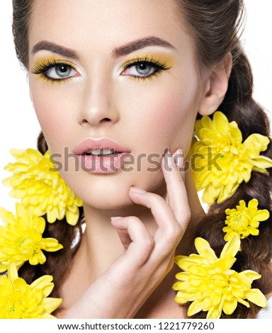 Closeup face of an young beautiful woman with bright yellow make-up. Fashion portrait. Attractive girl with stylish hairstyle, pigtails -   isolated on white. Professional  makeup. Skin care.