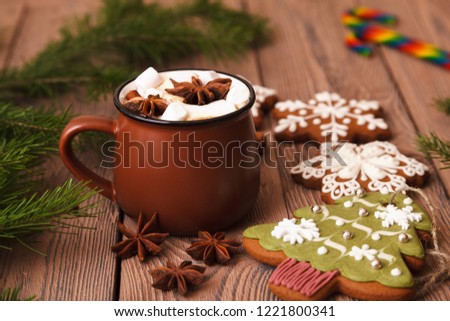 Christmas or New year background. A Cup of festive hot chocolate or cocoa with marshmallows. Traditional homemade gingerbread cookies on the table. Christmas advertising cocoa. New year's still life