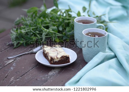 horizontal photo of a saucer with a cake, and mint sprigs to contrast with the background.