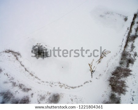 drone image. aerial view of rural area with fields and forests in snowy winter. textures in snow