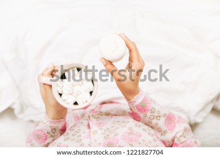 coffee and marshmallows in women's hands.top view