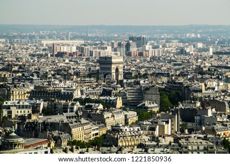 Photo taken from above the Eiffel Tower with deep view of the city with the arc of triumph centralized. Overcast
