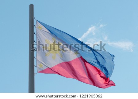 Flag of Philippines in the wind on the blue sky background