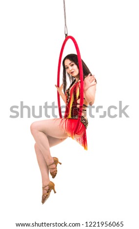 A young girl, with long dark hair, dances and performs in an airy ring in a stage costume. Studio shooting, isolated image.