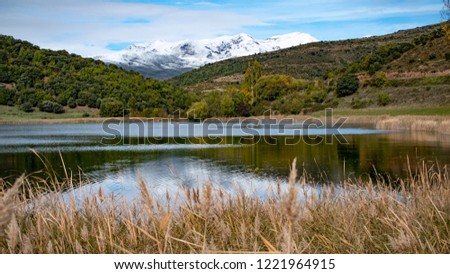 Natural landscape composed of snowy mountains and a lake inside.