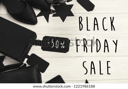 Black Friday big sale text sign, minimalistic flat lay. Special discount christmas offer. Stylish advertising message at black gift boxes, price tags on white rustic background. Christmas shopping
