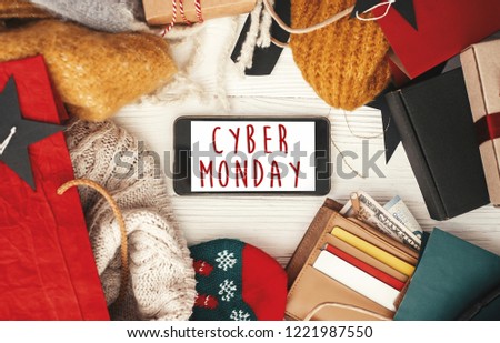 Cyber Monday sale text sign on phone screen, flat lay. Special discount christmas offer. Phone with advertising message at credit cards, money, bags, gift boxes,price tags. Shopping time.