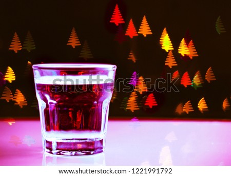 Drink shot in a shot glass on a Christmas tree-shaped bokeh background, Christmas decoration on the bar, xmas party