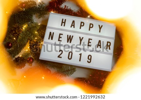 Happy New year 2019 displayed on a vintage lightbox with decoration for New Year's Eve, light frame, view from above