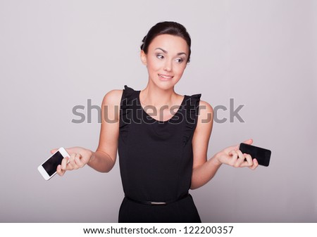 the beautiful girl holds two phones