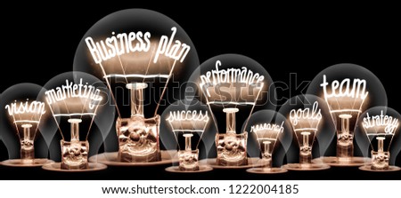 Photo of light bulb with shining fiber in a shape of BUSINESS PLAN concept related words isolated on black background