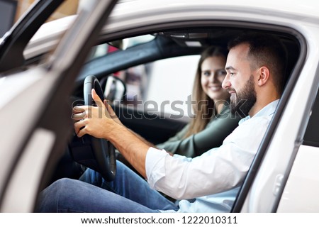Adult couple choosing new car in showroom Royalty-Free Stock Photo #1222010311