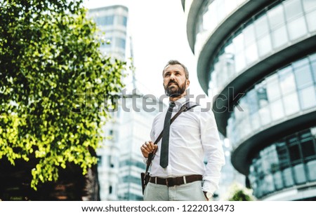 Hipster businessman walking outdoors on the street in London city.