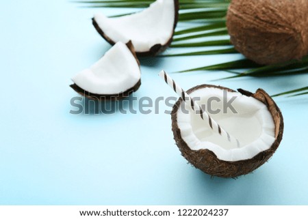 Coconut water with straw on blue background