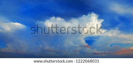 Wide panoramic view of romantic navy blue sky with white orange and grey clouds. High resolution artistic skyline background image. Beautiful sky panorama