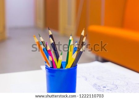 Colored pencils in a blue pencil case standing on the table