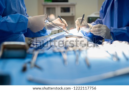 Asian doctor and an assistant in the operating room for surgical venous vascular surgery clinic in hospital. Royalty-Free Stock Photo #1222117756
