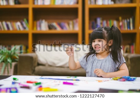 Cute little girl painting a picture at home