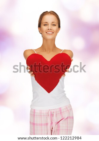 picture of happy and smiling woman with heart-shaped pillow