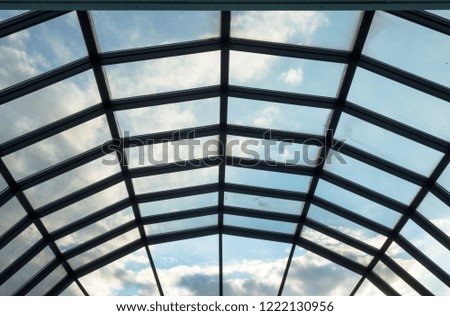 Modern glass roof with steel grid frames. Skylight rooftop window with symmetrical grid steel beams. Architectural detail and design on glass rooftop