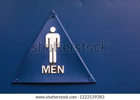 Modern public men triangle toilet sign on blue door at the entrance with copy space