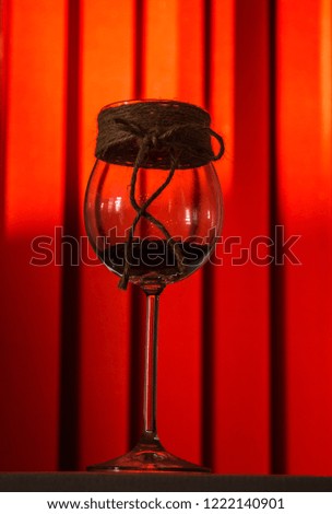 Beautiful glass with candles on a red background.