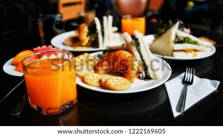Coffee Break Set. Delicious continental snack with fresh flaky, assorted preserves, orange juice, cookies, sandwich and coffee, close up on the croissants.