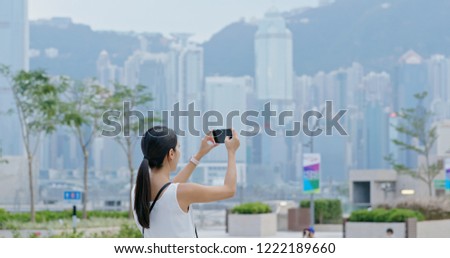 Woman take photo on cellphone in Hong Kong city