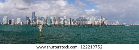 Miami cityscape skyline from Rickenbacker causeway on cloudy morning with Manatee zone slow speed sign