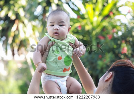 Infant baby in hold your mom and walk to out side for fresh oxygen in the garden
