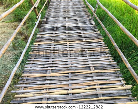Thai wooden bridge walk way over canal or ditch to enter old style Thai house
