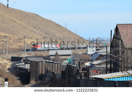 This picture shows a train coming with a house on foreground