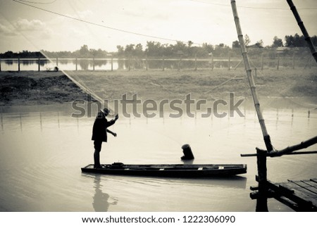 fisherman casting net on the river